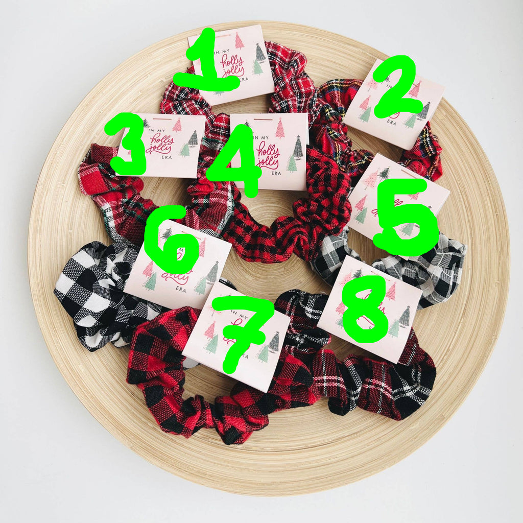 Plaid scrunchies with holiday-themed cards on a wooden tray