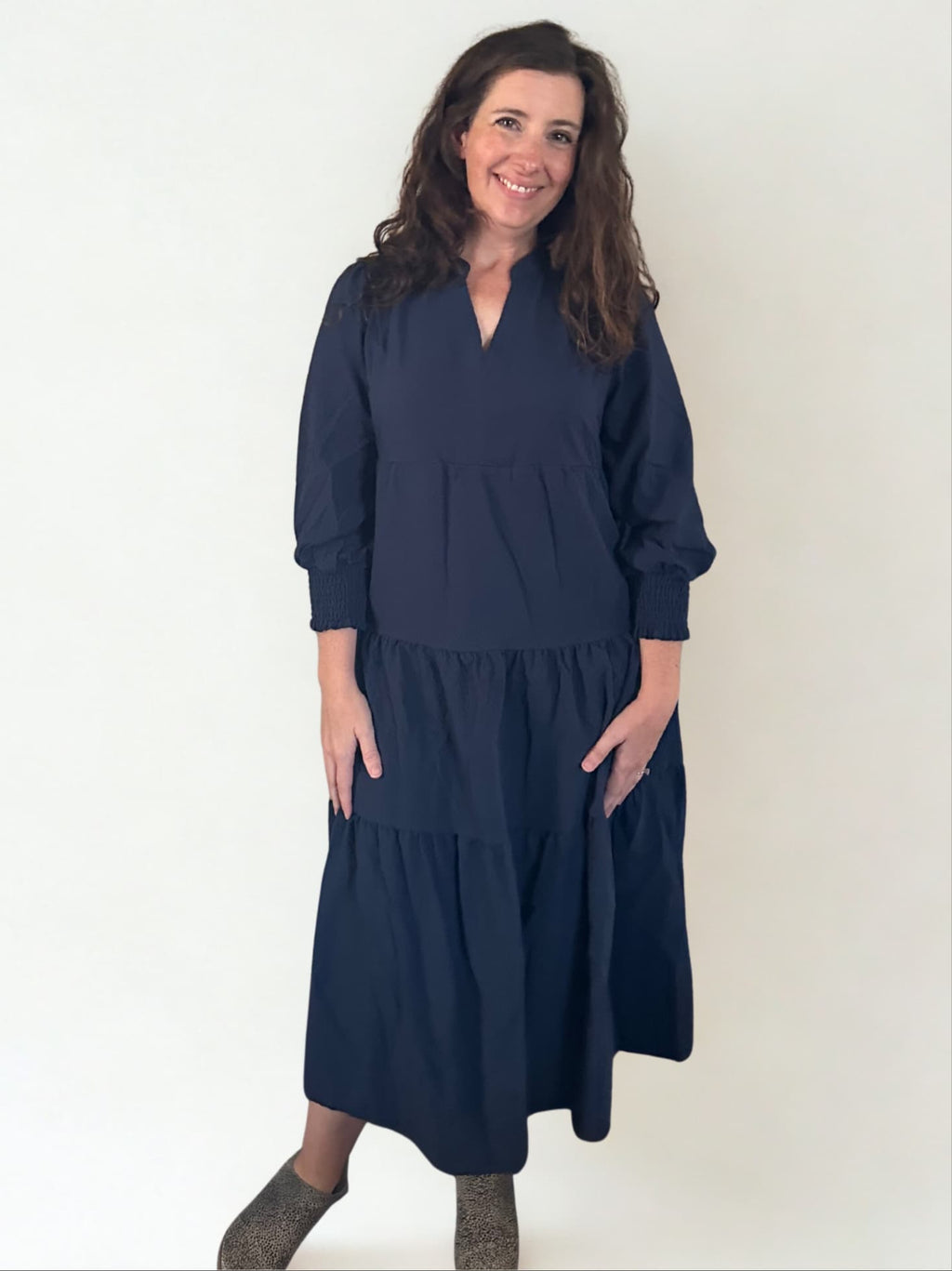 Woman wearing a navy blue dress against a white background