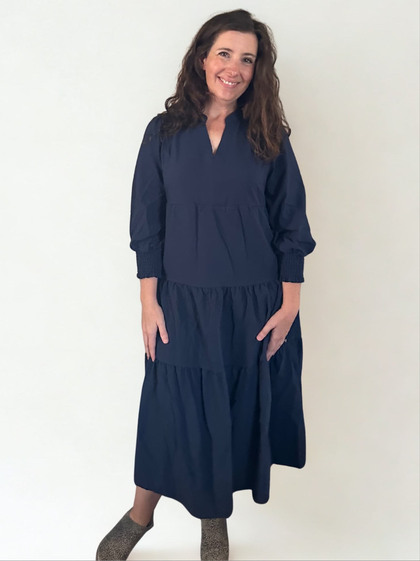 Woman wearing a navy blue dress against a white background