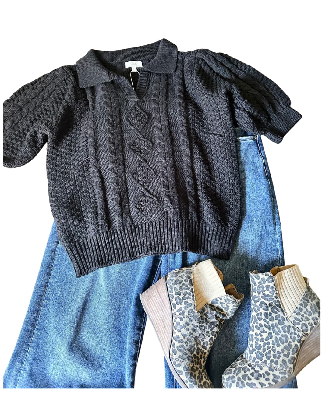Classic cable knit sweater with collar, V-neck, and puff sleeves in black, styled with blue jeans and leopard print wedge ankle boots.