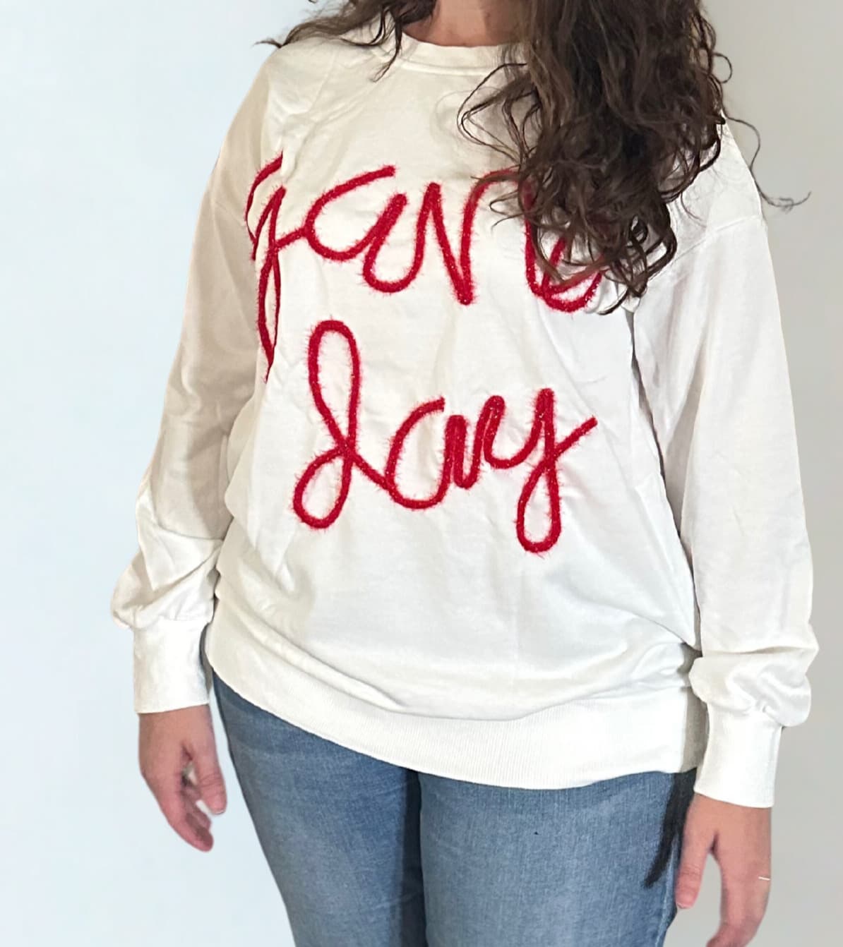 close up of white sweatshirt with game day red tinsel graphic