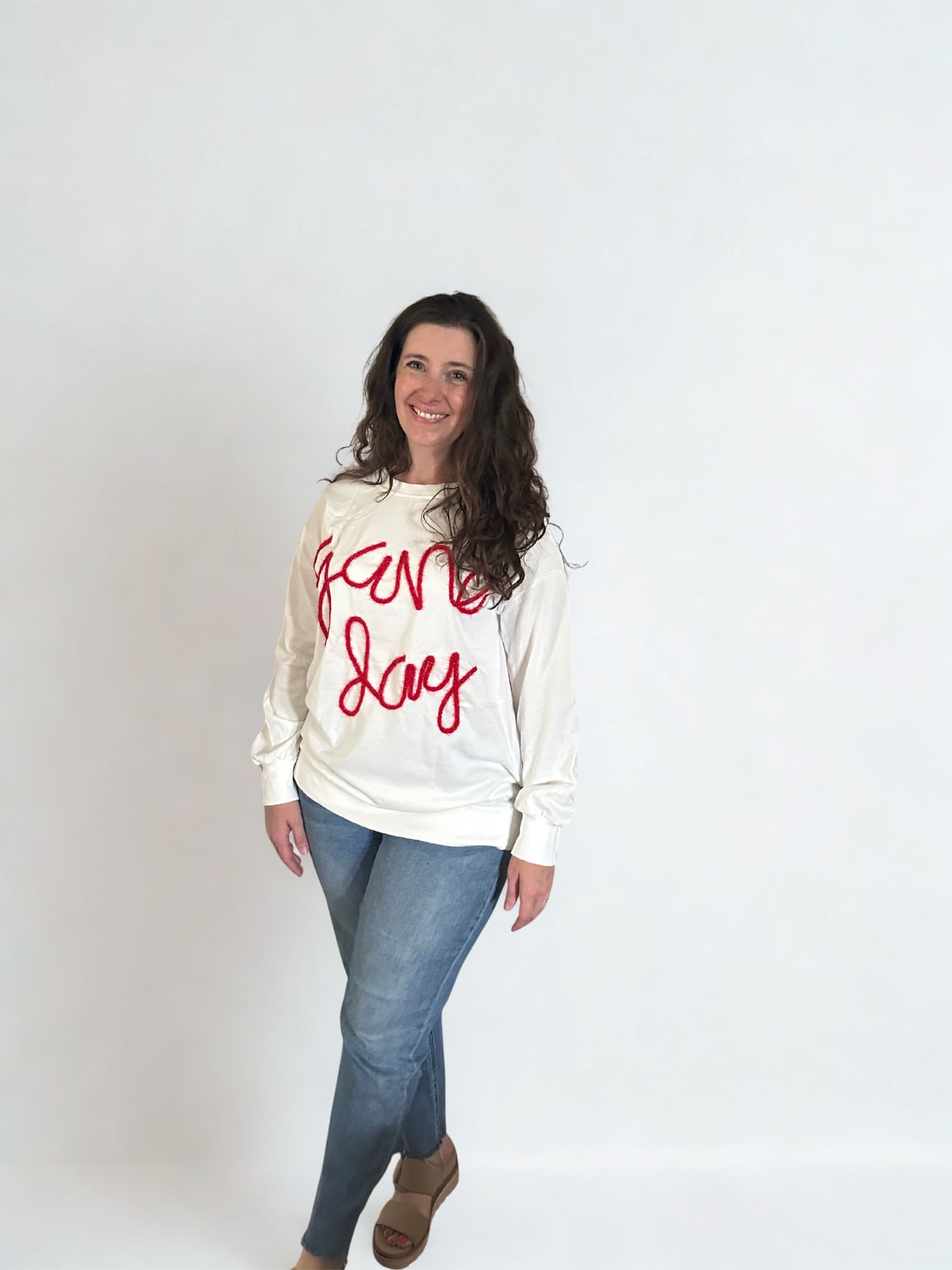 woman wearing white sweatshirt with red game day lettering